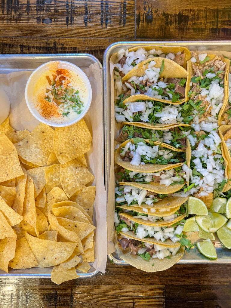 casual Dallas restaurant La Ventana with two trays of food one with tacos and the second tray has chips and queso